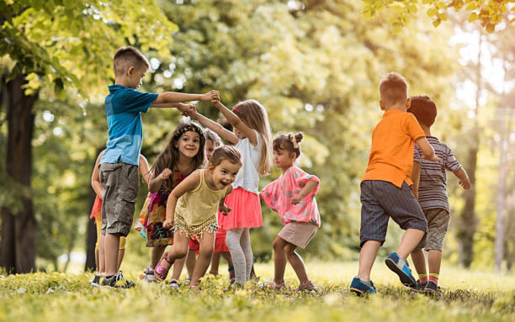 Group of happy little children having fun in the park.
